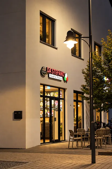 Eingang mit Terrassenstühlen und Laterne am Abend