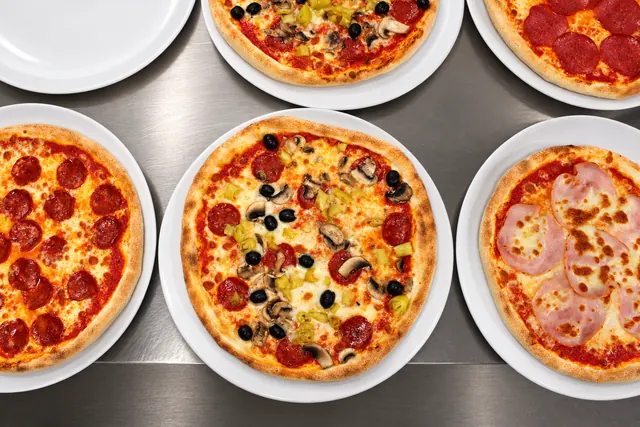 Fünf Pizzen frisch aus dem Ofen – Salami, Prosciutto und mehr