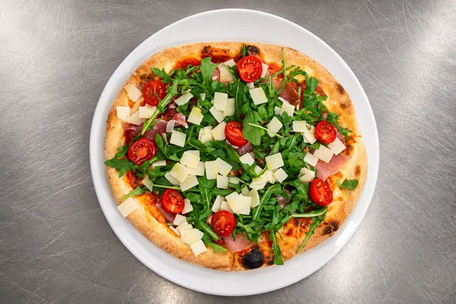 Pizza mit Rucola, Parmaschinken, Kirschtomaten und Parmesan